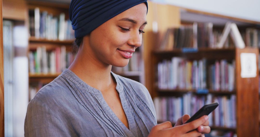 Smiling Woman Using Smartphone in Library Background - Free Images, Stock Photos and Pictures on Pikwizard.com