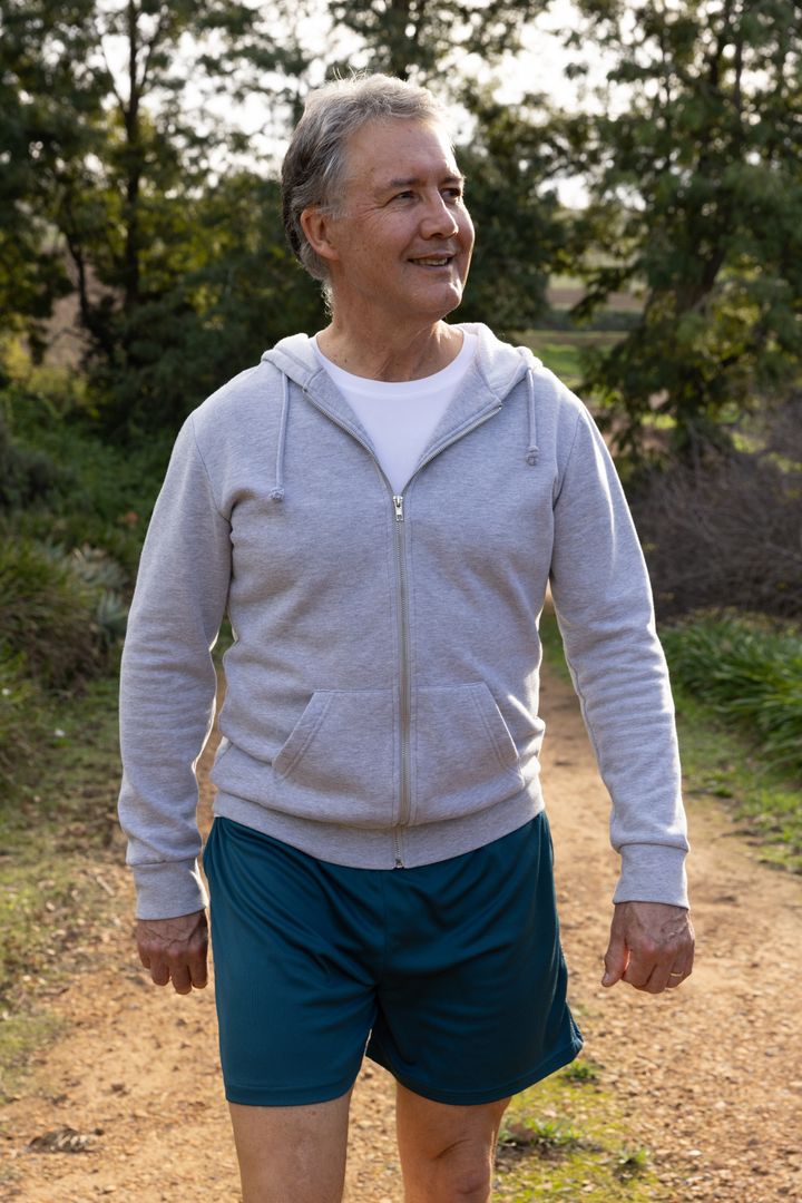 Senior Man Walking Through Park Trail in Activewear