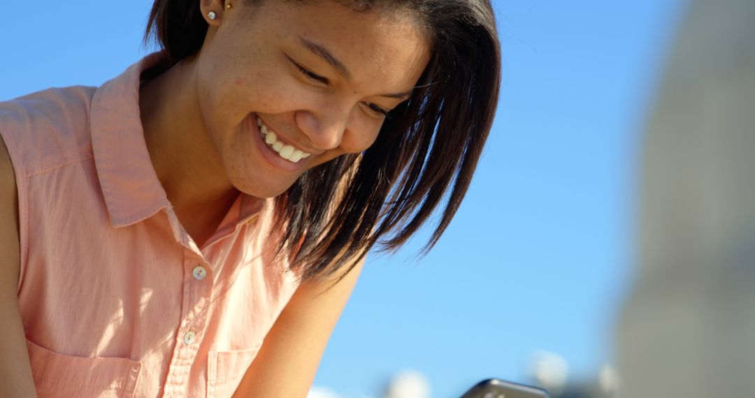 Smiling Young Woman Enjoying Smartphone Outdoors - Free Images, Stock Photos and Pictures on Pikwizard.com