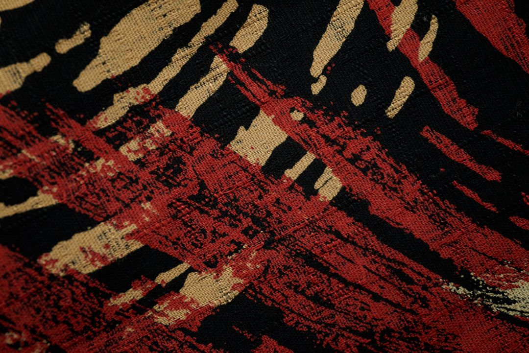Featuring red and beige brushstroke pattern on black woven textile for abstract design