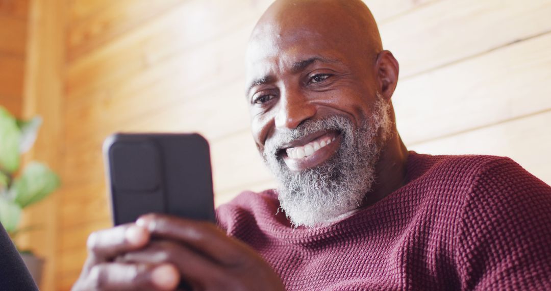 Smiling Bearded Man Enjoying Smartphone Indoors - Free Images, Stock Photos and Pictures on Pikwizard.com