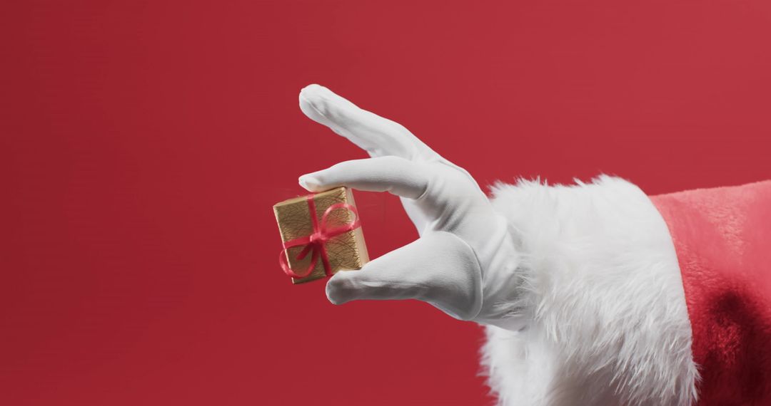 Santa Claus Holding Tiny Gift Box on Red Festive Background