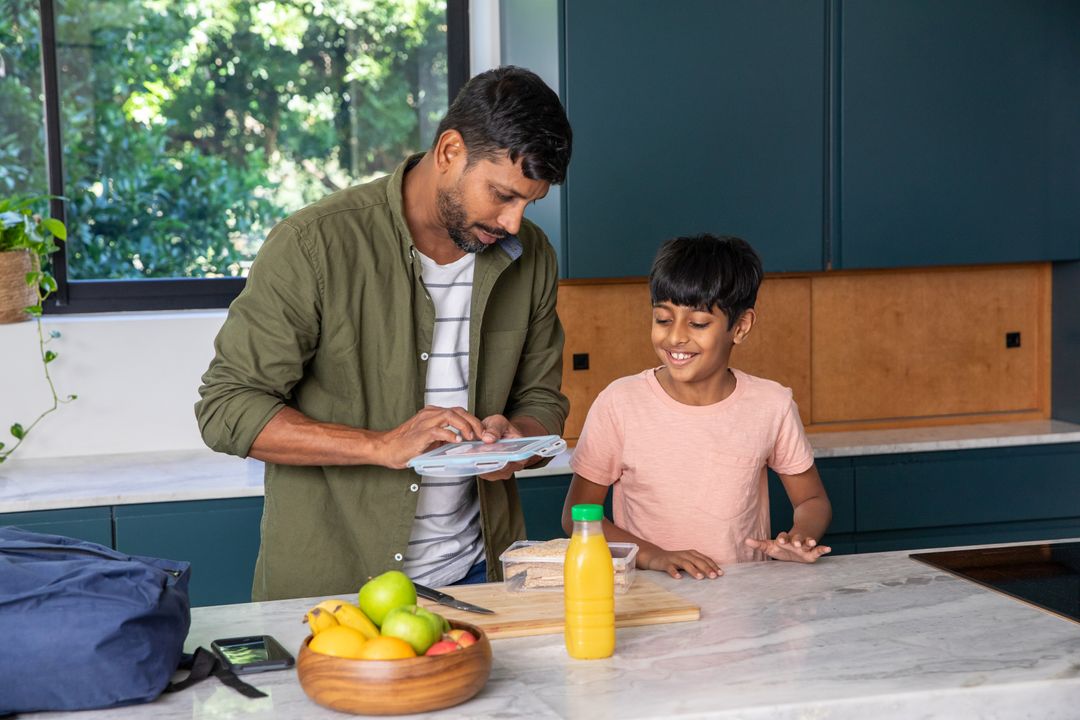 Father and Son Bonding While Preparing Lunch Together in Modern Kitchen