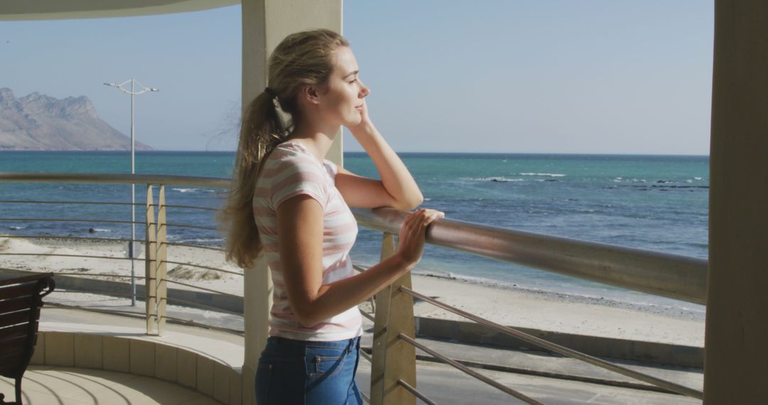 Young Woman Relaxing on Beachfront Balcony - Free Images, Stock Photos and Pictures on Pikwizard.com