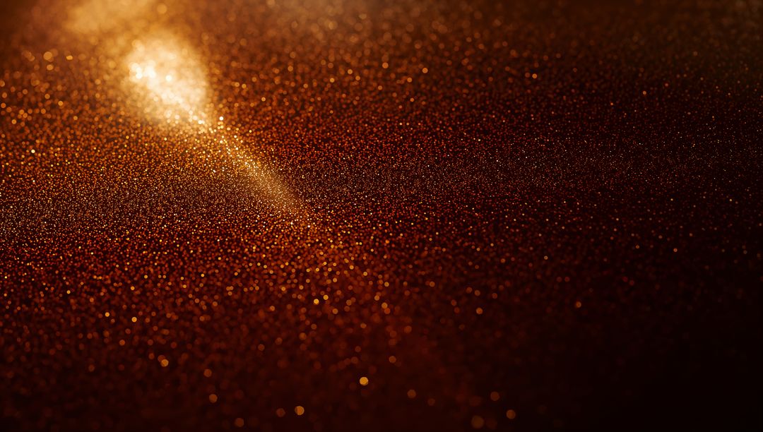 Golden glitter bokeh macro background with warm metallic sparkle and amber light flare