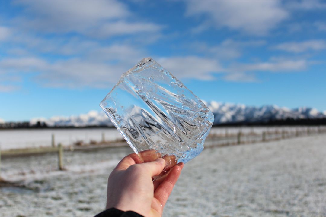 Hand Holding Clear Ice Block in Snowy Countryside - Free Images, Stock Photos and Pictures on Pikwizard.com