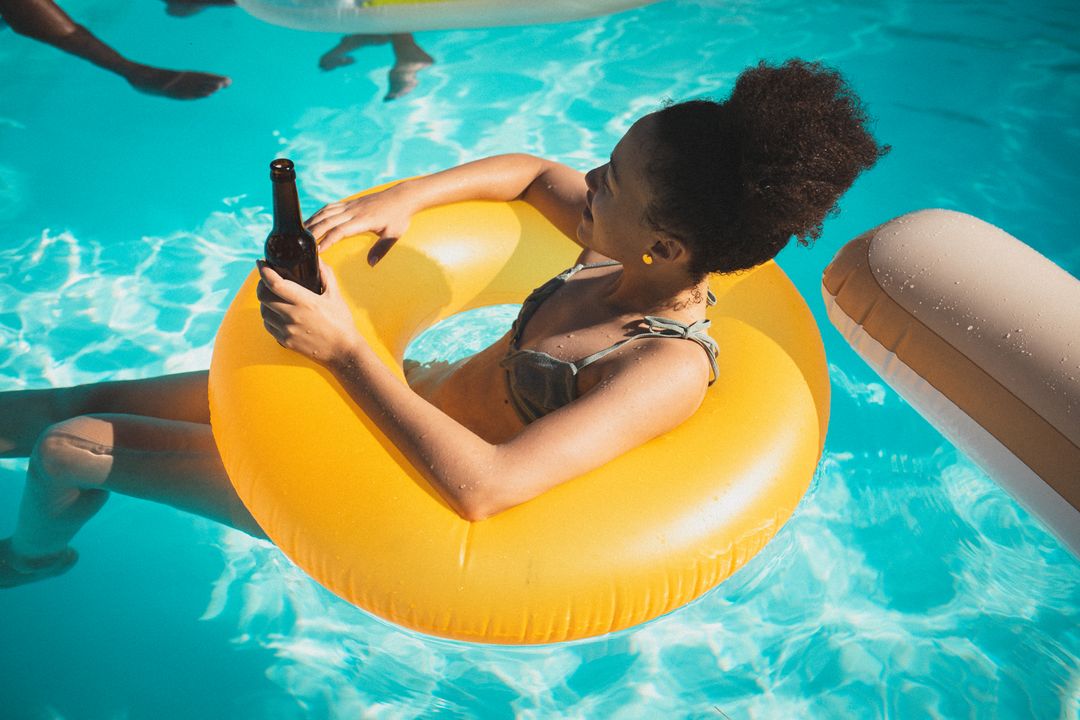 Woman Relaxing in Pool with Inflatable Ring and Beer - Free Images, Stock Photos and Pictures on Pikwizard.com