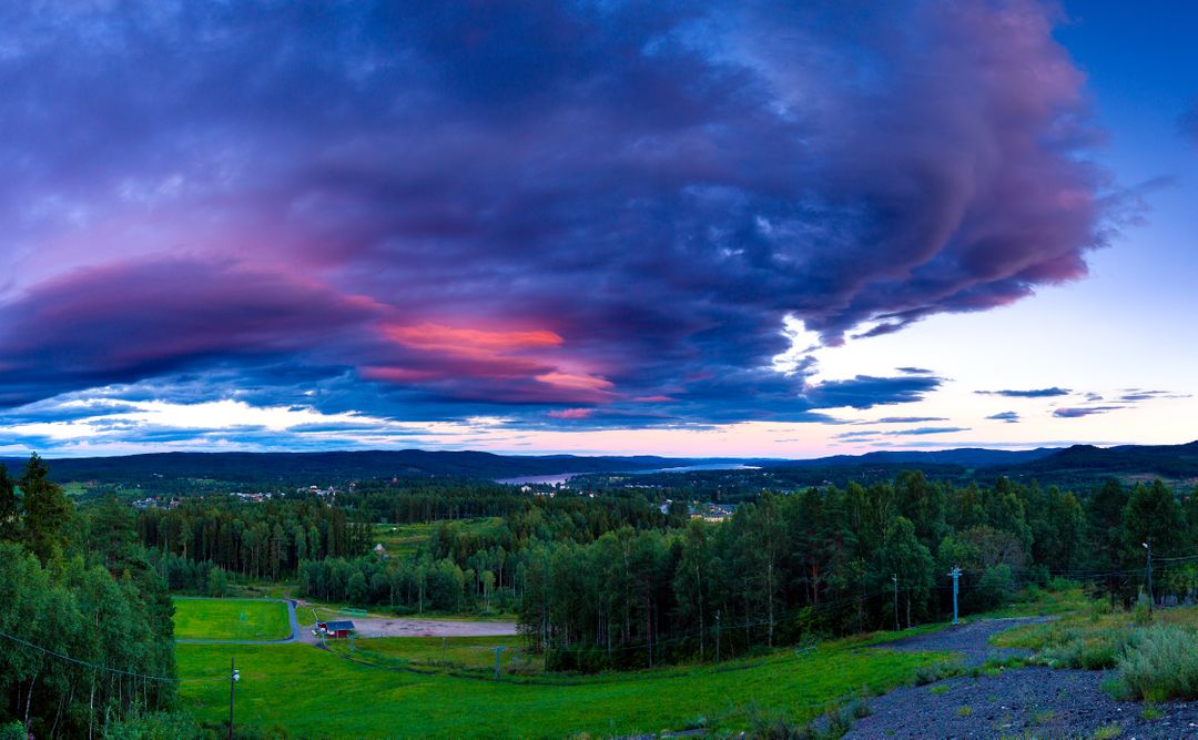 Dramatic Sunset with Purple Clouds Over Green Forest Valley - Free Images, Stock Photos and Pictures on Pikwizard.com