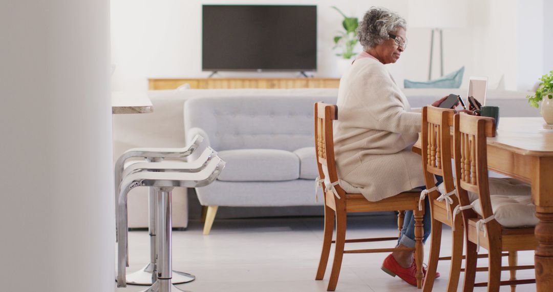 Senior Woman Relaxing in Cozy Living Room Reading Tablet - Free Images, Stock Photos and Pictures on Pikwizard.com