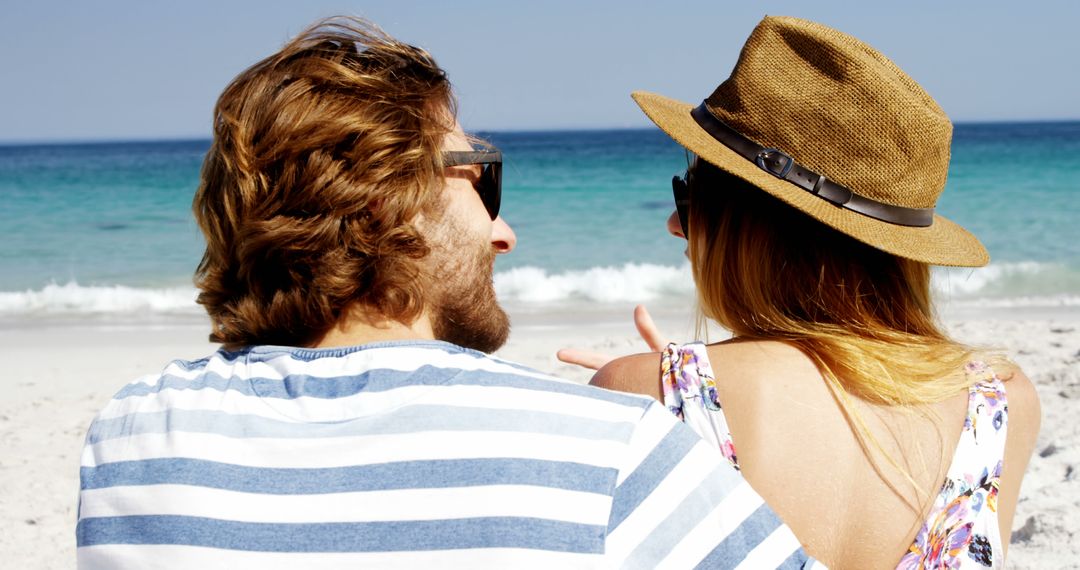 A young Caucasian couple enjoys a sunny beach day, with copy space - Free Images, Stock Photos and Pictures on Pikwizard.com