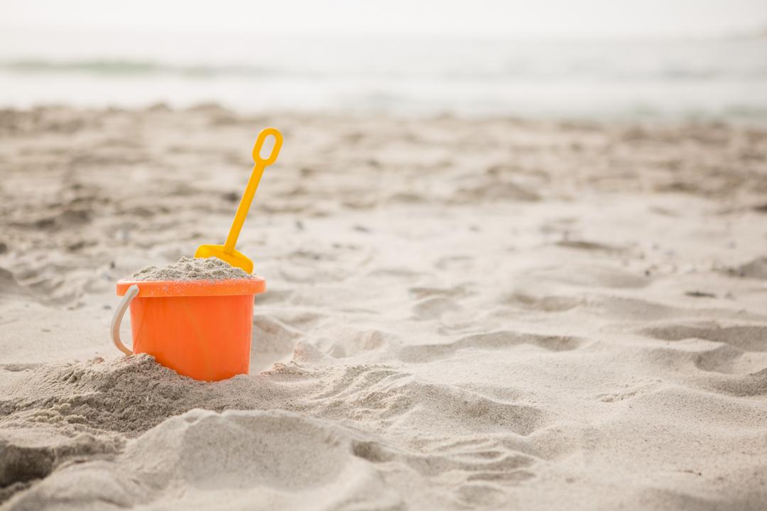 Orange Bucket and Spade on Sandy Beach - Free Images, Stock Photos and Pictures on Pikwizard.com