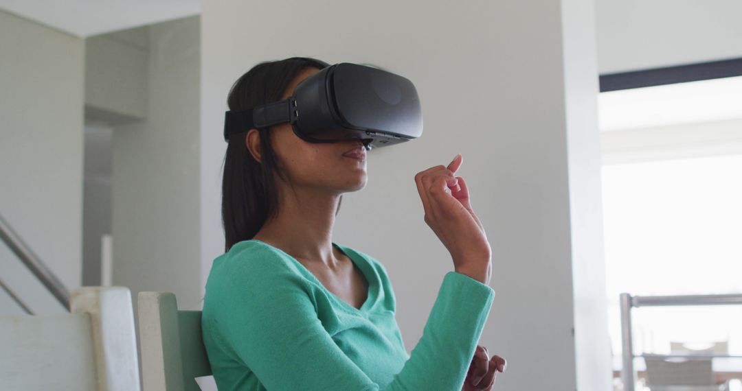 Woman Engaging Virtual Reality Sitting Indoors, Using VR Headset - Free Images, Stock Photos and Pictures on Pikwizard.com