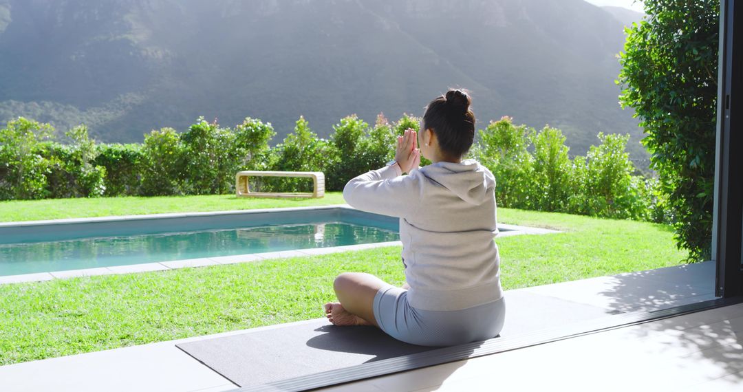 Woman Meditating Poolside in Tranquil Outdoor Setting