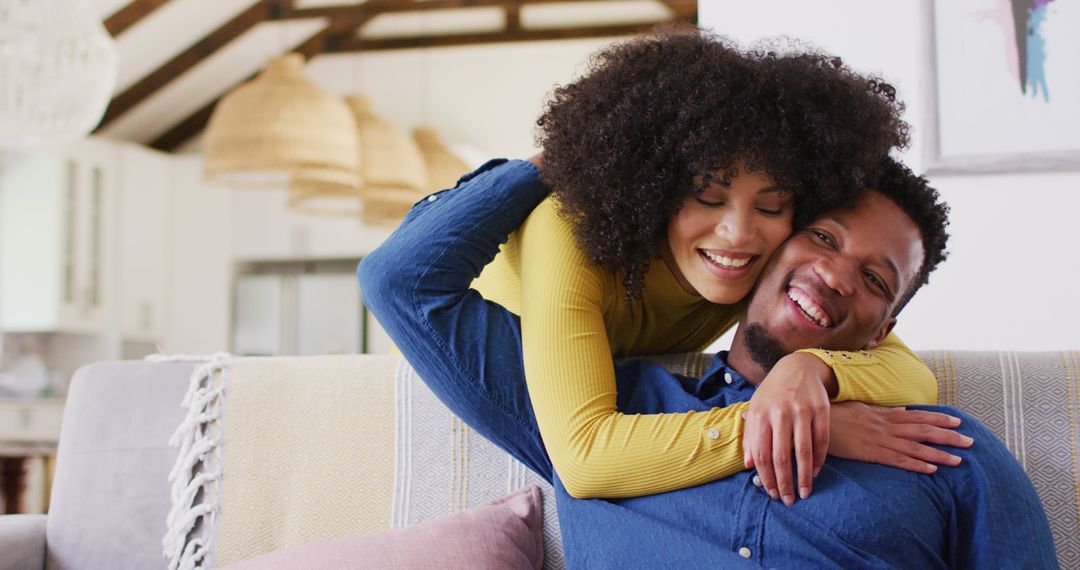Happy african american couple embracing in living room - Free Images, Stock Photos and Pictures on Pikwizard.com