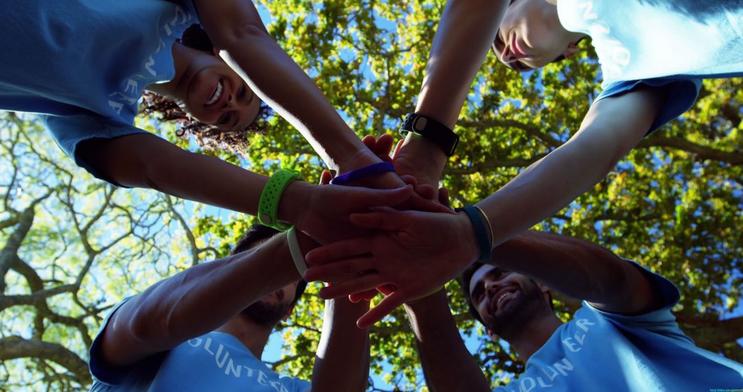 Diverse Volunteers Stacking Hands in Outdoor Teamwork