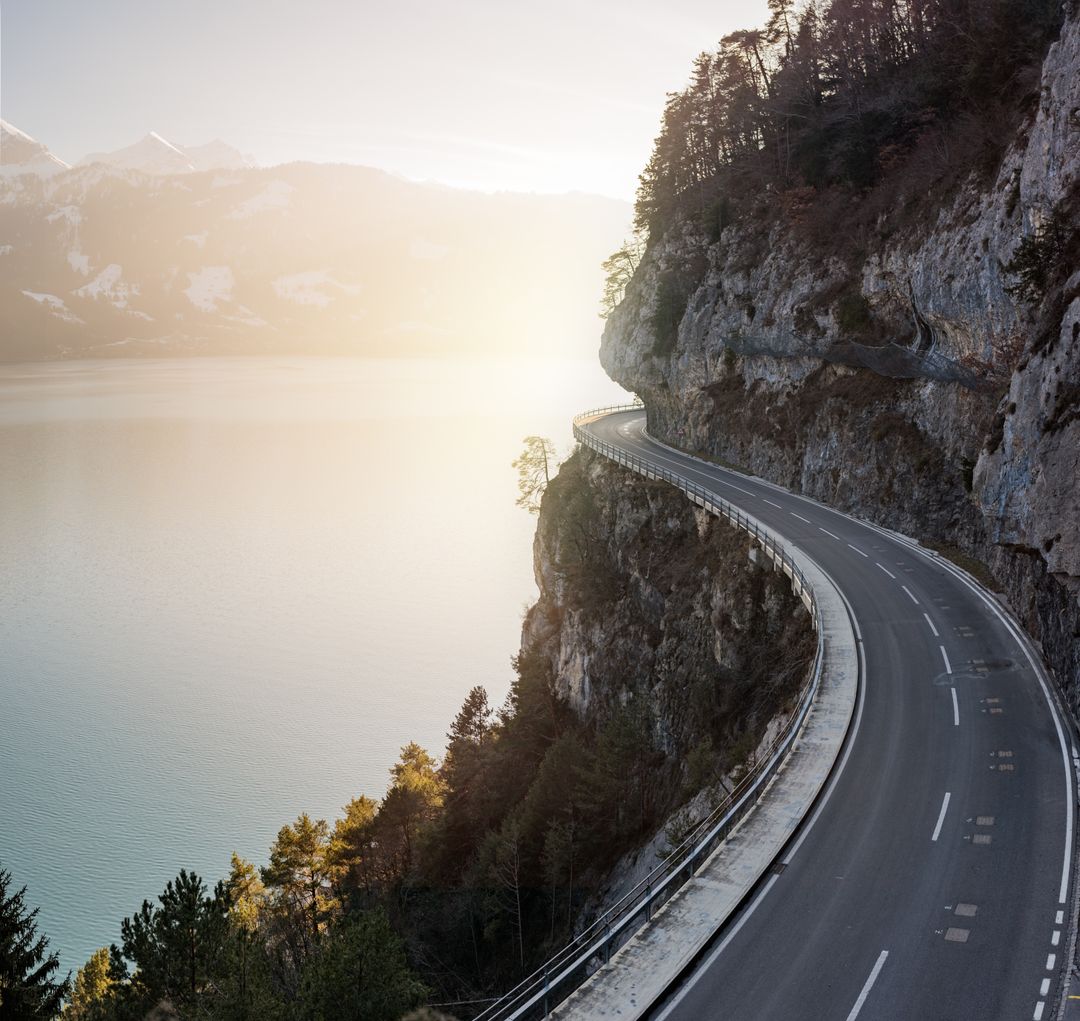Scenic Mountain Road Overlooking Serene Lake at Sunset