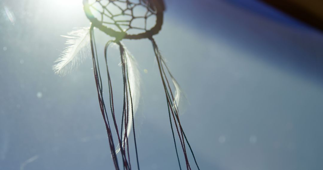 Dreamcatcher with Sunlight and Feathers Against Blue Sky - Free Images, Stock Photos and Pictures on Pikwizard.com