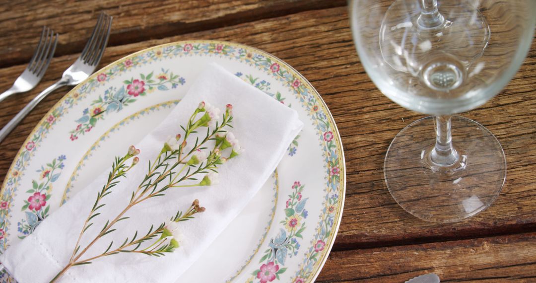 Elegant Table Setting with Floral Plate, White Napkin, and Wine Glass - Free Images, Stock Photos and Pictures on Pikwizard.com