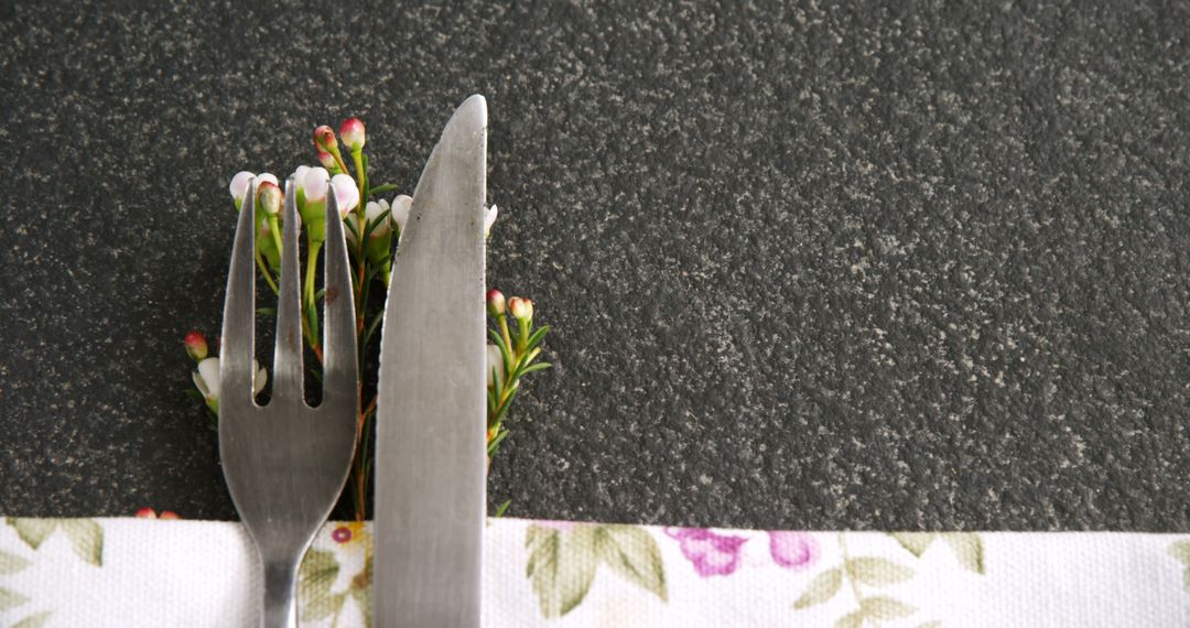 A fork and knife are neatly placed on a floral napkin, with copy space - Free Images, Stock Photos and Pictures on Pikwizard.com