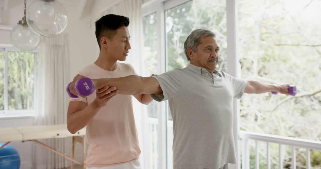 Young Trainer Helping Elderly Man Exercise with Dumbbells - Free Images, Stock Photos and Pictures on Pikwizard.com