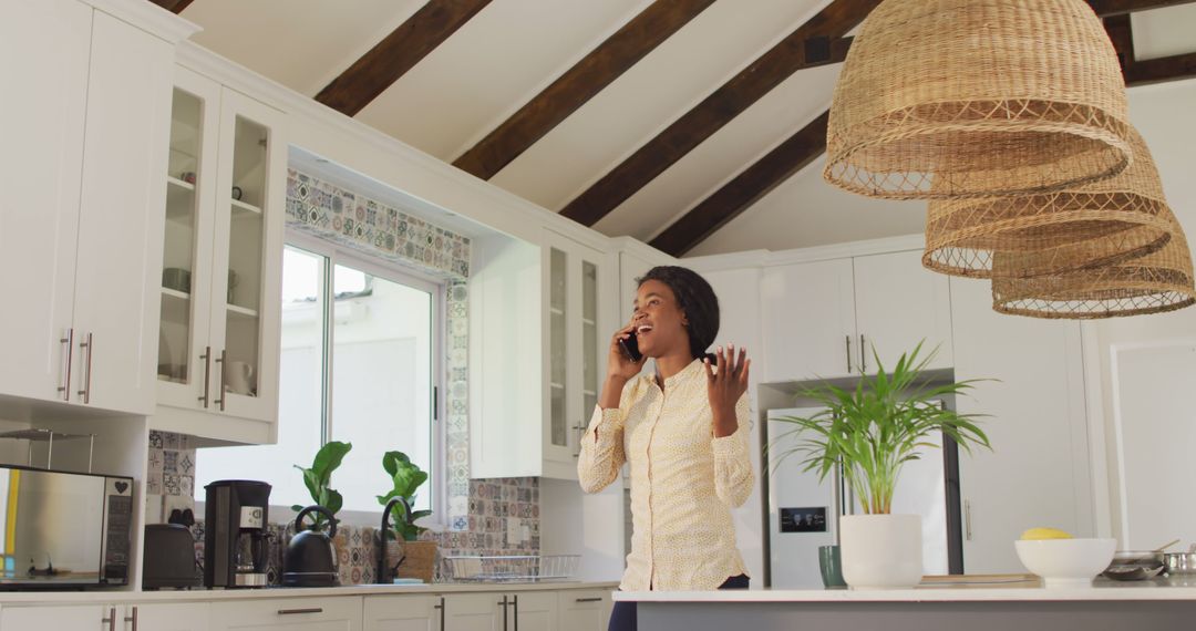 Excited Woman Talking on Phone in Modern Kitchen with Vaulted Ceiling - Free Images, Stock Photos and Pictures on Pikwizard.com