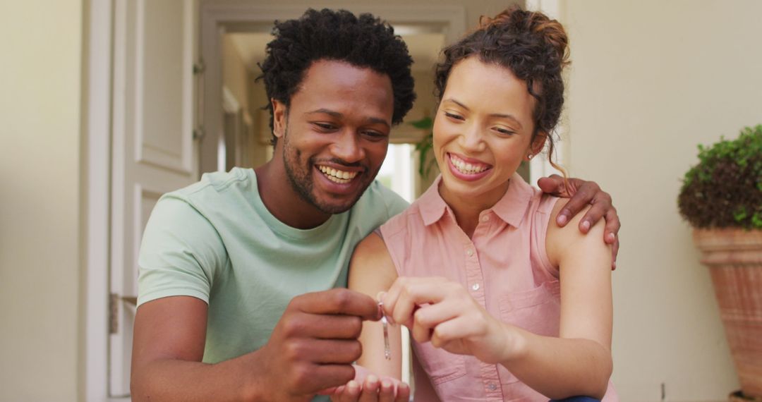 Happy Couple Holding Keys Celebrating New Home Purchase