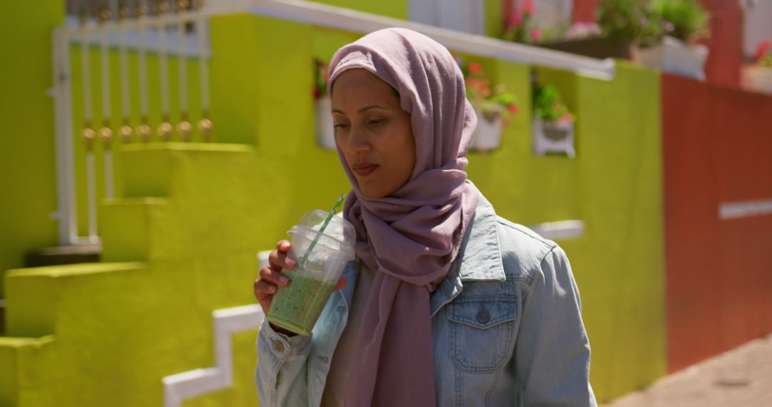 Young Woman in Hijab Enjoying a Green Smoothie Outdoors - Free Images, Stock Photos and Pictures on Pikwizard.com