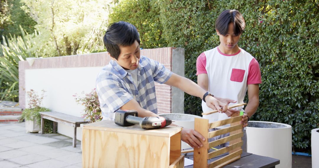 Father and Son Collaborating on Crate Assembly Outdoors
