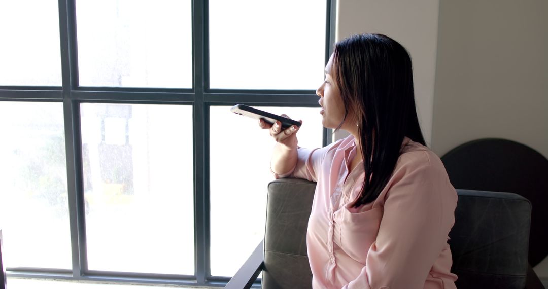 Executive Woman Using Smartphone Voice Command in Modern Office