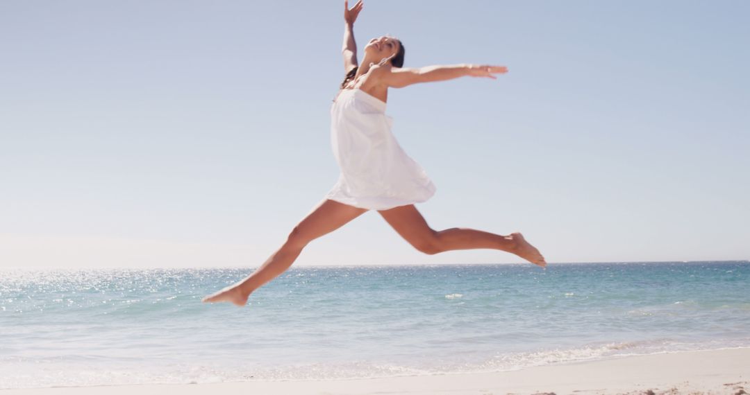 Woman Leaping Joyfully on Beach in Summer Dress - Free Images, Stock Photos and Pictures on Pikwizard.com