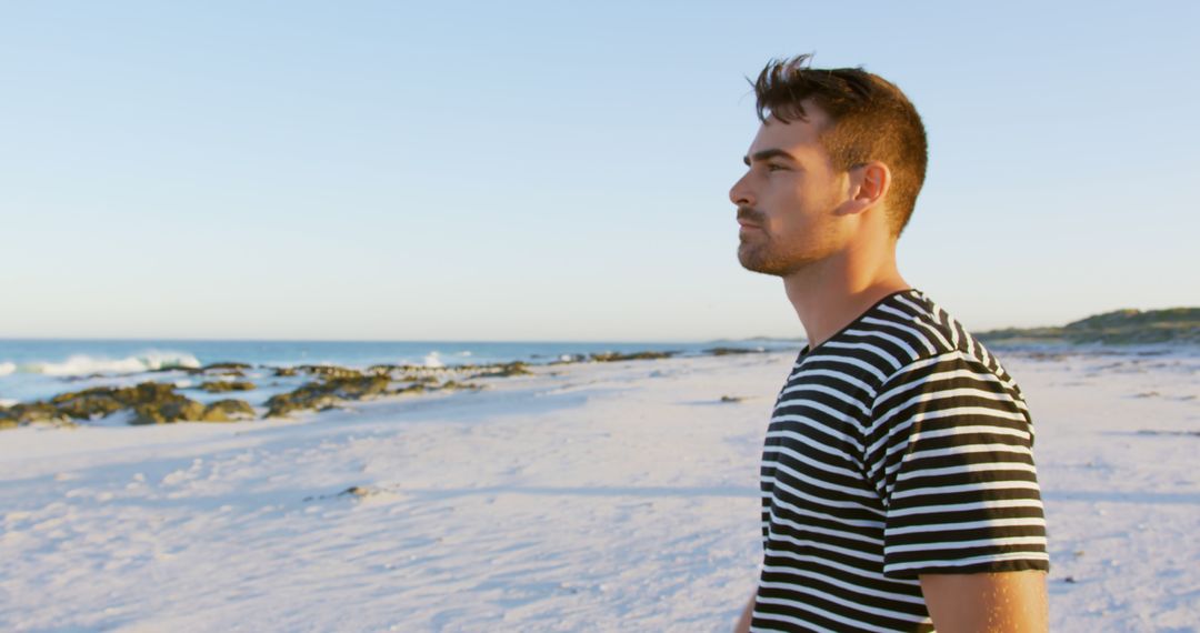 Pensive Young Man Enjoying Beach Sunset in Striped Shirt - Free Images, Stock Photos and Pictures on Pikwizard.com