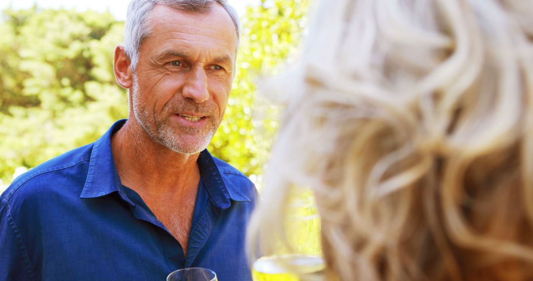 Senior Man Holding Wineglass Conversing Outdoors - Free Images, Stock Photos and Pictures on Pikwizard.com