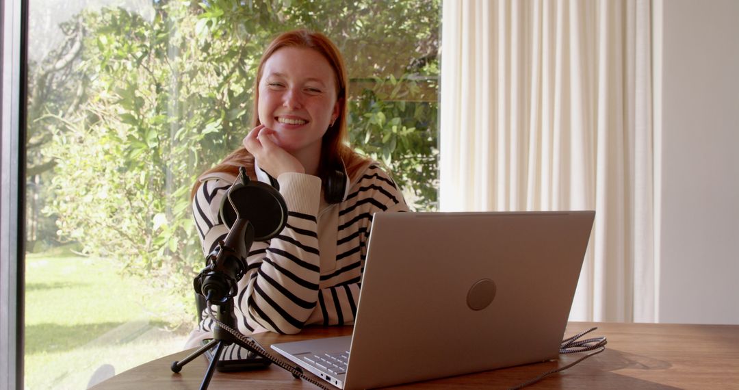Woman Podcasting From Home Using Laptop Microphone and Headphones