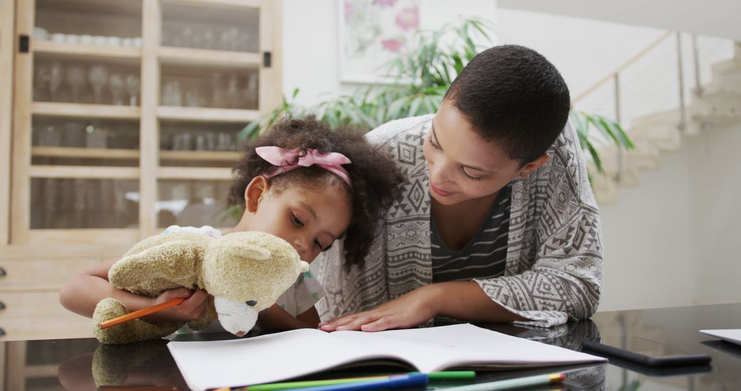 Mother Helping Daughter with Homework Alongside Teddy Bear - Free Images, Stock Photos and Pictures on Pikwizard.com