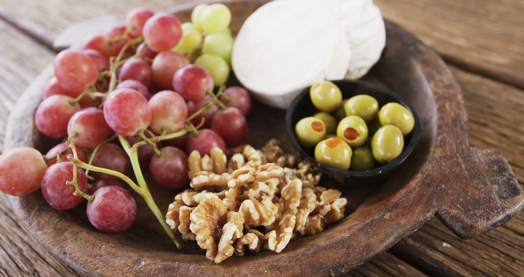 Rustic Wooden Platter with Grapes, Cheese, Walnuts, and Olives - Free Images, Stock Photos and Pictures on Pikwizard.com