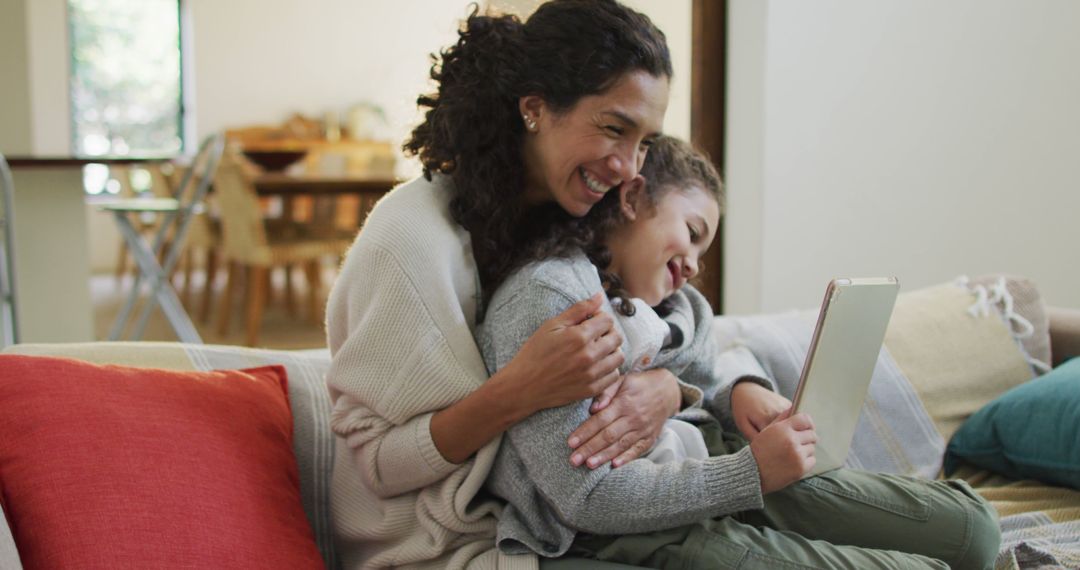 Smiling Mother Hugging Daughter While Using Tablet at Home - Free Images, Stock Photos and Pictures on Pikwizard.com