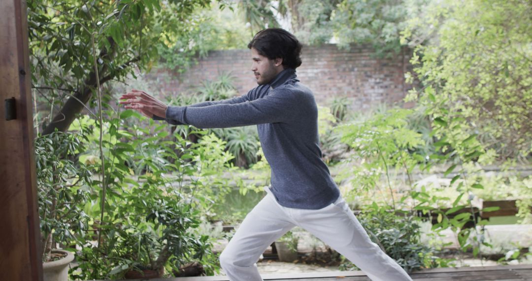 Man Practicing Tai Chi in Garden Amidst Lush Greenery - Free Images, Stock Photos and Pictures on Pikwizard.com