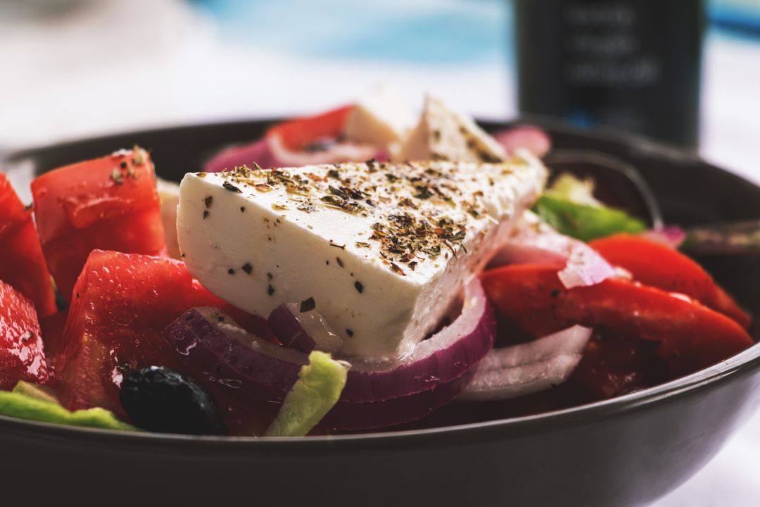 Greek Salad Featuring Herb-Crusted Feta, Ripe Tomatoes, Red Onion and Kalamata Olives