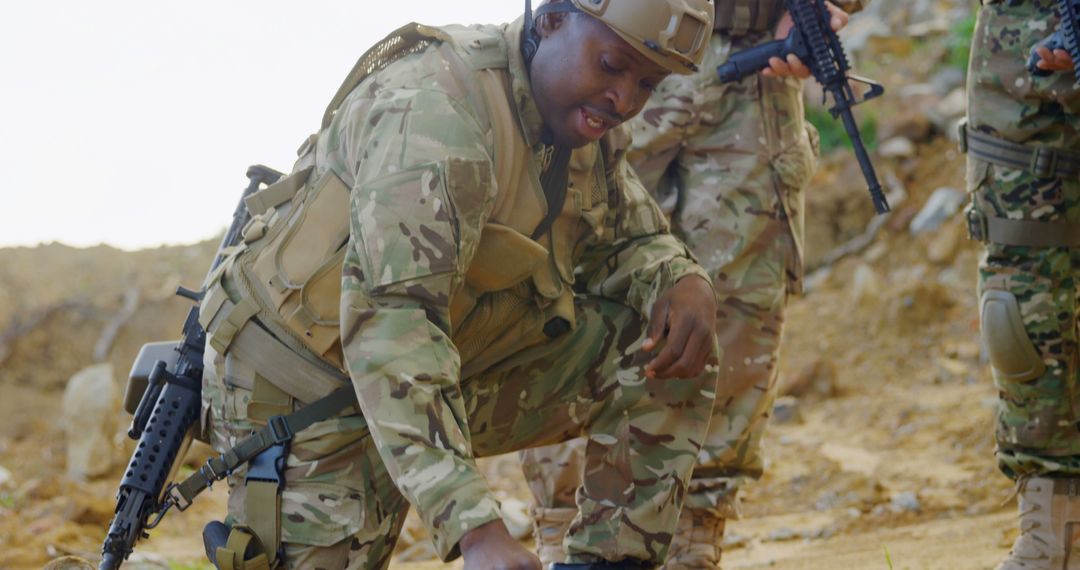 African American Soldier Analyzing Terrain with Team in Desert Environment