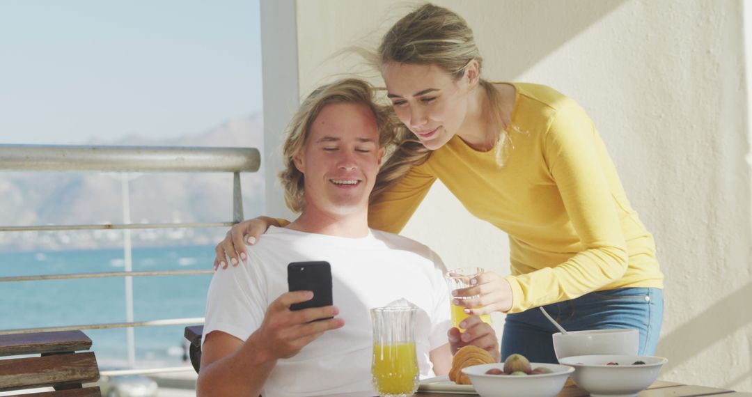 Happy Couple Enjoying Balcony Breakfast with Ocean View