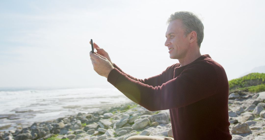 Man Taking Photo with Smartphone by Seaside - Free Images, Stock Photos and Pictures on Pikwizard.com