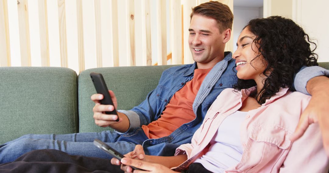Happy Couple Relaxing Together on Sofa with Smartphones