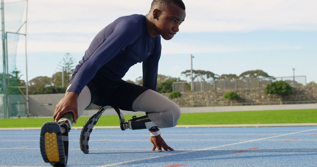 Focused Athlete with Prosthetic Legs Preparing for Sprint on Track - Free Images, Stock Photos and Pictures on Pikwizard.com