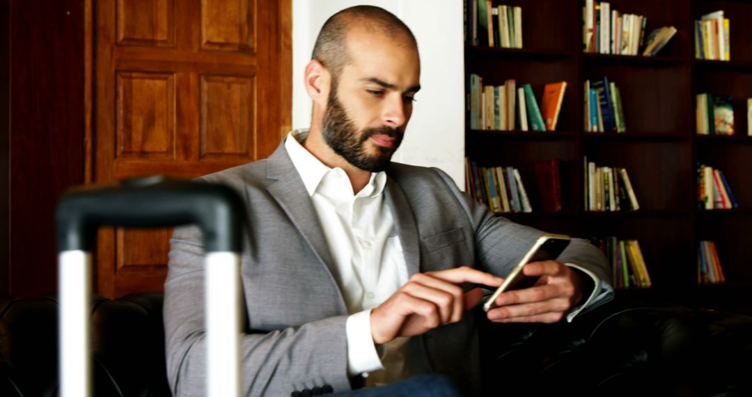 Businessman Using Smartphone in Relaxed Library Setting
