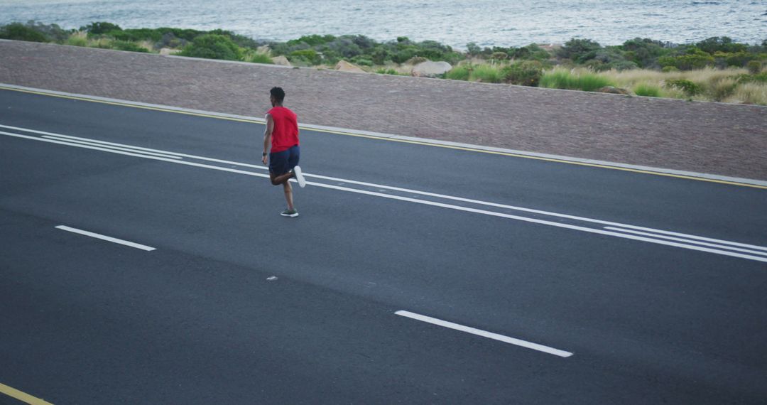 Man Jogging on Seaside Road for Morning Exercise - Free Images, Stock Photos and Pictures on Pikwizard.com