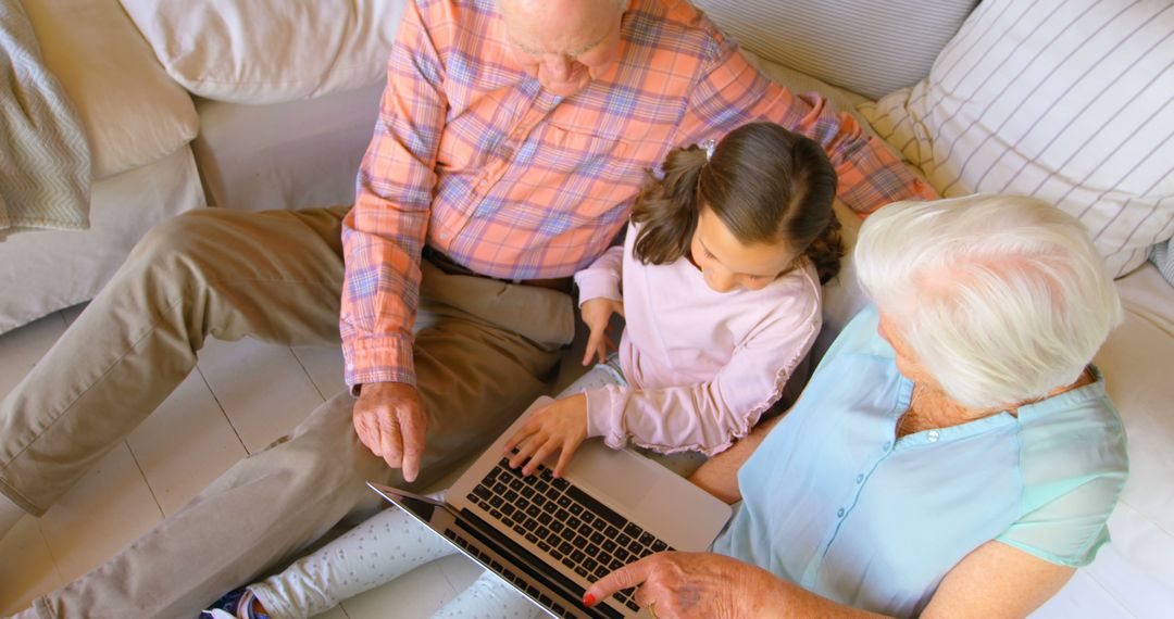 Grandparents Teaching Granddaughter Laptop on Sofa - Free Images, Stock Photos and Pictures on Pikwizard.com