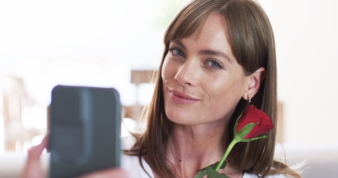 Smiling Woman Taking Selfie with Red Rose at Home