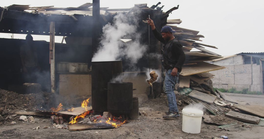 Man Lighting Fire Near Industrial Scrap Materials - Free Images, Stock Photos and Pictures on Pikwizard.com