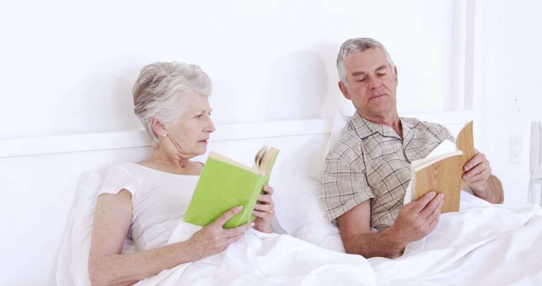 Senior couple reading book in bed - Free Images, Stock Photos and Pictures on Pikwizard.com