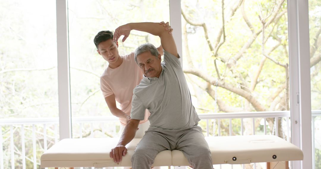 Therapist Assisting Elderly Man with Physical Therapy Stretches - Free Images, Stock Photos and Pictures on Pikwizard.com